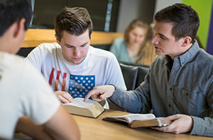 Student reading with mentor