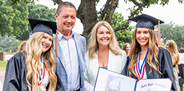 student standing with parents after graduating from a Christian college in Texas