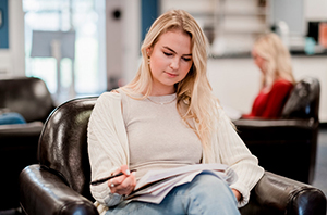 college girl sitting on a chair working on her budget