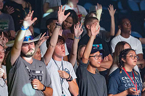 group of Christian college students worshipping the Lord with hands raised