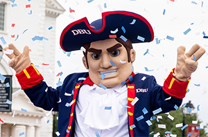 DBU Patriot man outside with confetti falling down