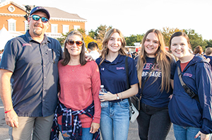 college students in a group photo with their parents during homecoming