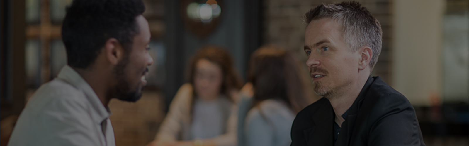 college student talking with a faculty member while enjoying coffee