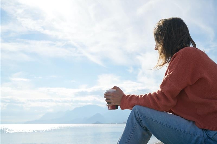 Girl sitting by the ocean
