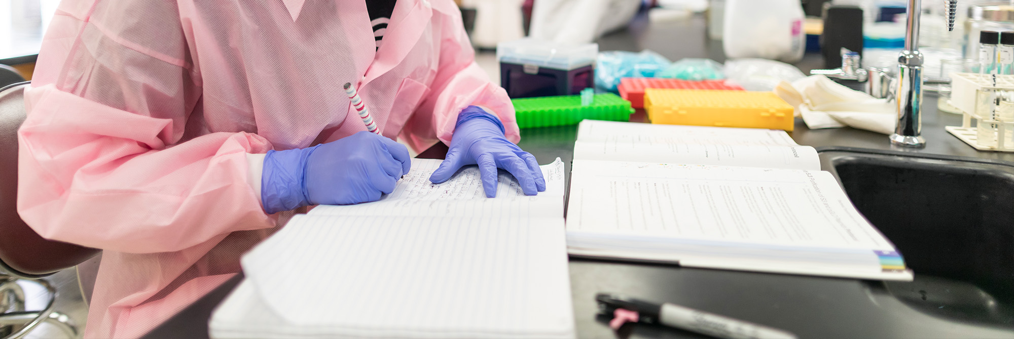 student taking notes in a lab